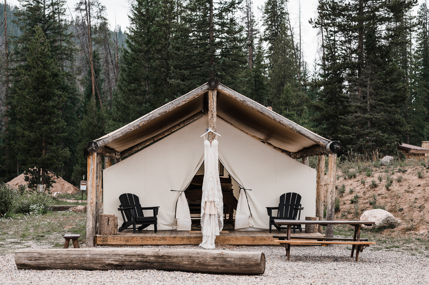 Beaded and Lace wedding dress hanging on glamping tent at Piney River Ranch