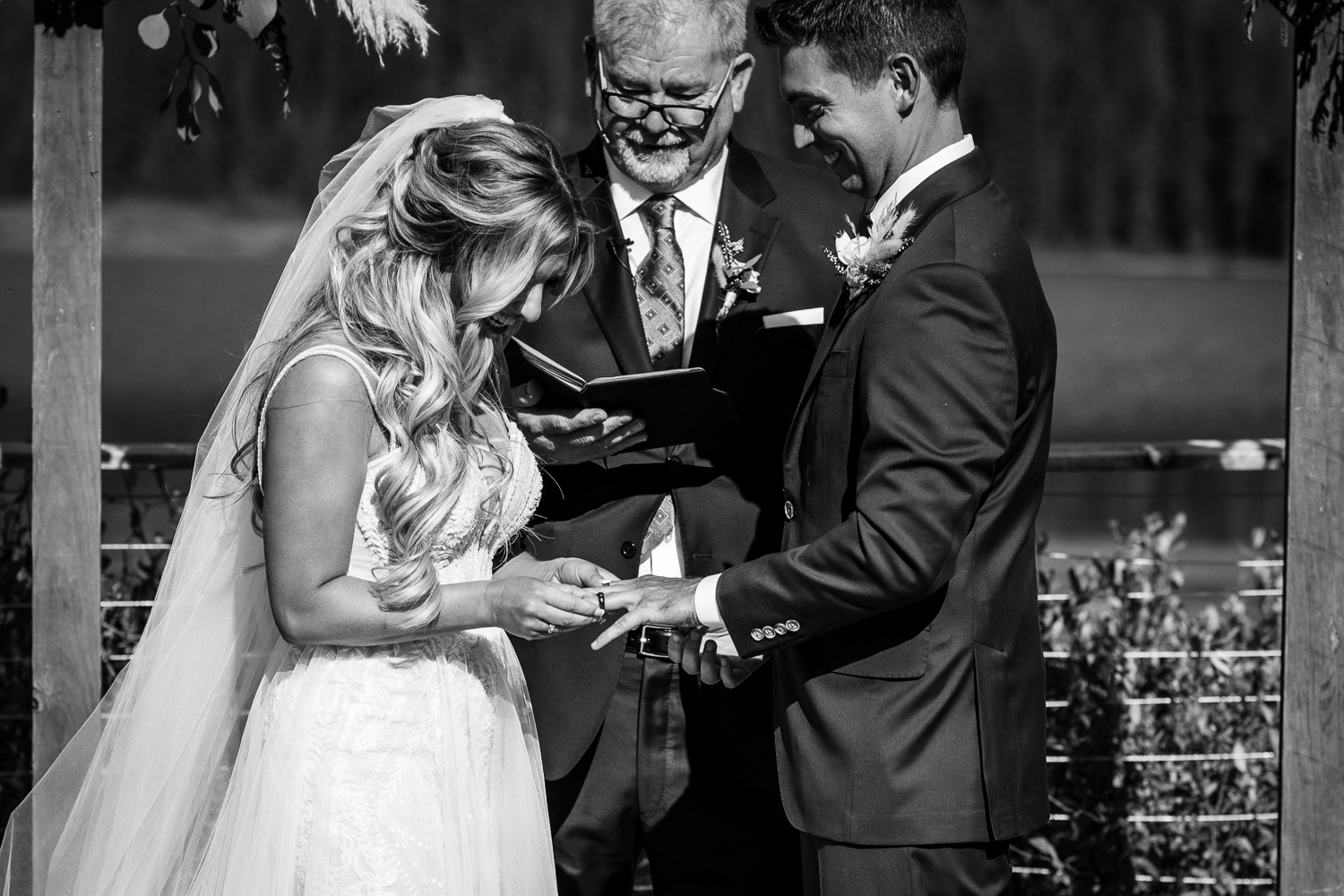 Black and white image of bride putting ring on groom at Piney River Ranch Vail CO