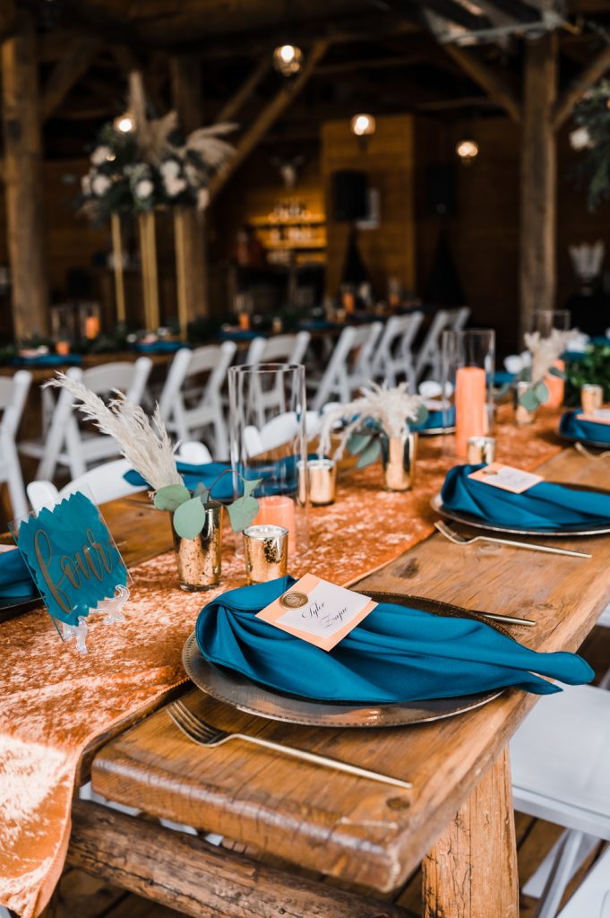 Wedding farm table setting with rust and teal colors